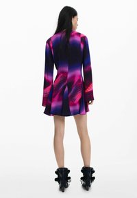 Lühikeste varrukatega, laiendatud kleit erksates lilas ja roosas värvigraadis, millel on abstraktsed mustrid, tagaküljel lõhik ja voolav alusäär.