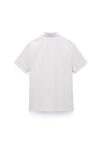 Polo met korte mouwen en kraag in licht beige. Gemaakt van gladde stof, met een klassieke snit en subtiele stiksel details op de mouwen.