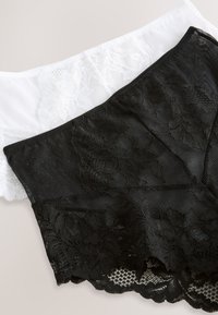 Dvi nėrinių šortai: vieni juodi su gėlių raštu ir permatomais akcentais, kiti balti su atitinkančiais nėriniais. Abu turi minkštą elastinę juosmens juostą.