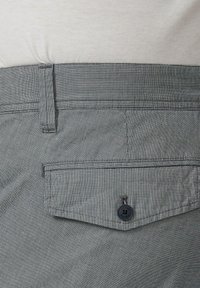 Grijs-wit gestreepte stof met een achterzak voorzien van een knoopsluiting. De tailleband heeft een textuurontwerp.