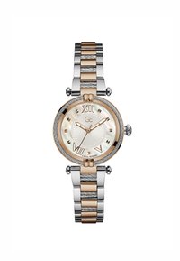 Montre ronde avec un bracelet en métal bicolore argent et or. Présente un cadran en nacre, des chiffres romains et des accents texturés.