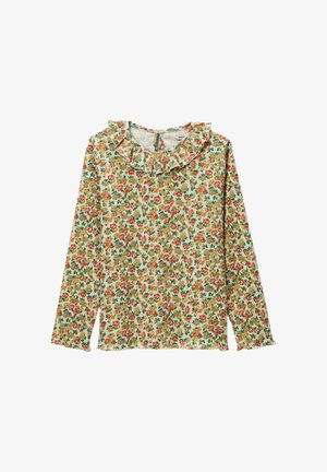 Blouse crème à manches longues avec un petit motif floral rouge, jaune et vert et un col volanté.