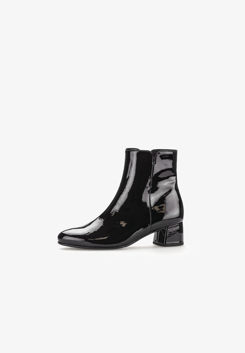 Bottine en cuir verni noir avec un bout pointu et un talon bloc moyen. Texture lisse avec des coutures minimales, conçue pour un port facile.