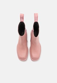 Paire de bottines roses à bouts carrés, fermetures éclair latérales et languettes portant la mention "CAMPER", vues de dessus sur fond blanc.