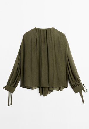 Olive green blouse with long sleeves, a relaxed fit, and pleated back detail. Features tie accents at the cuffs and a soft, textured fabric.