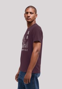 Maroon cotton T-shirt with short sleeves, featuring a white graphic design of Japanese characters and a wave pattern, casual fit.