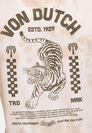 Tigre rugissant sautant en avant entre des drapeaux à damier, avec le texte « VON DUTCH ESTD. 1929 » et un slogan inspiré de la moto en dessous.