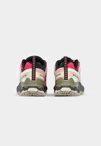 Trail running shoes with a pink mesh upper, black accents, a cushioned olive green sole, and a sturdy white heel counter.