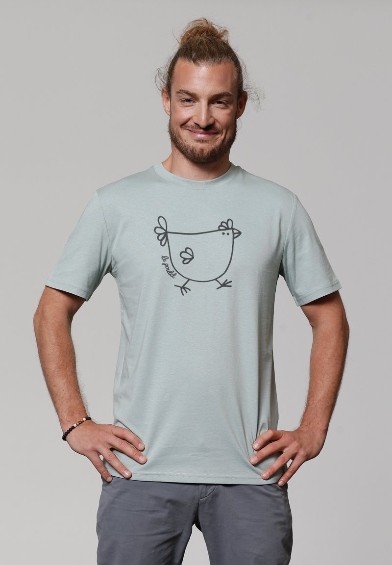 T-shirt à manches courtes de couleur bleu clair en tissu doux, avec un dessin au trait noir d'un poulet de dessin animé sur le devant.