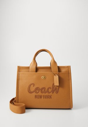 Tan leren Coach handtas met bovenhandvatten, afneembare schouderriem, voorvak en geperst "Coach New York" logo.