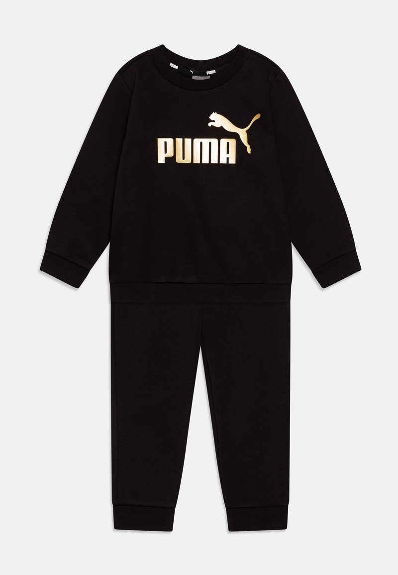 Črna trenirka z dolgimi rokavi in hlačami, ki ima zlat logotip "PUMA" in silhueto pume. Narejena iz mehkega blaga z rebrastimi manšetami.