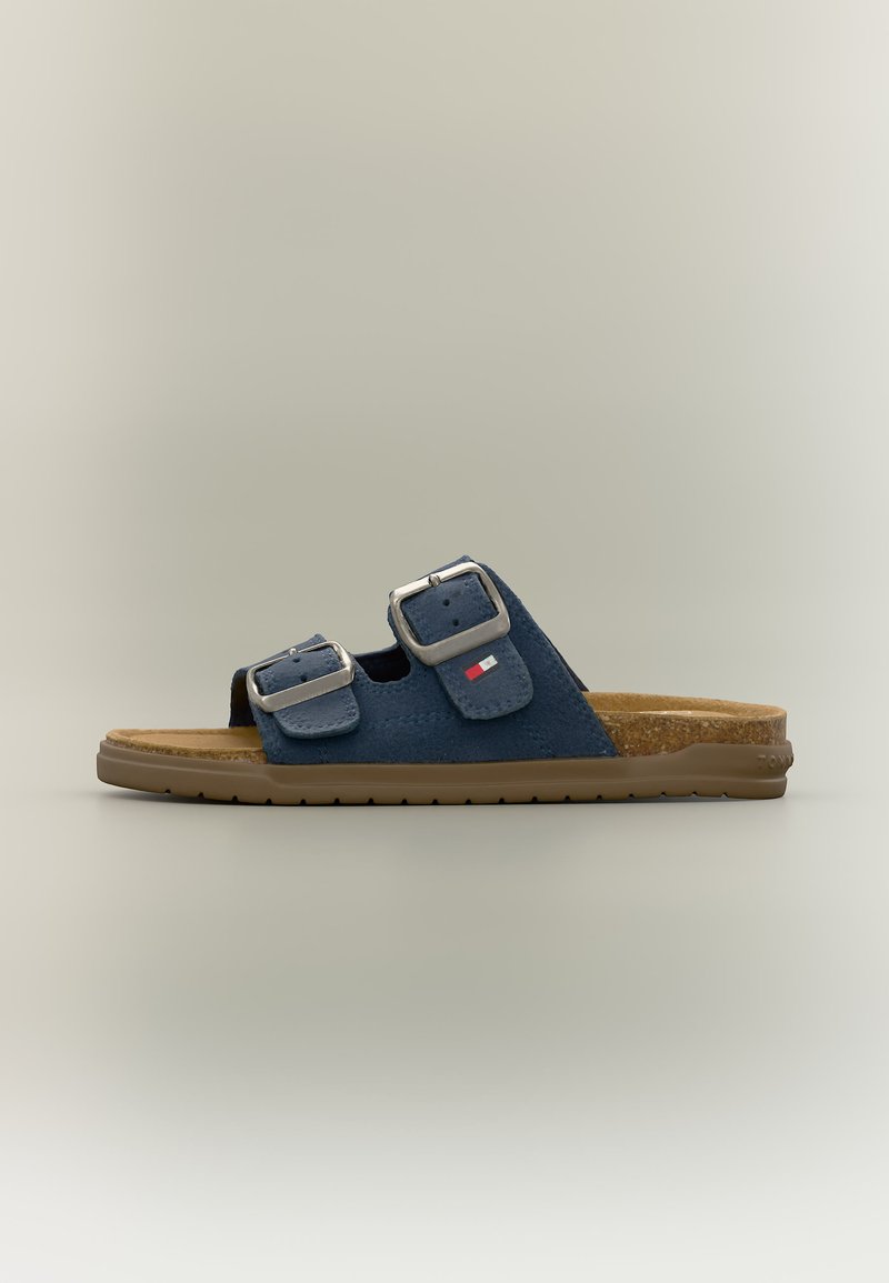 Σανδάλι σε μπλε ναυτικό χρώμα με δύο ρυθμιζόμενες ασημένιες αγκράφες, πάτο από φελλό, φωτεινό καφέ σόλα και μικρό λογότυπο σημαίας στο πλαϊνό λουράκι.