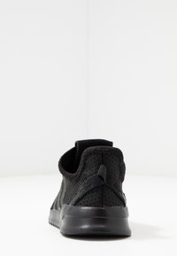 Svart träningssko med andningsbart mesh-överdrag, vadderad krage, texturerad sula och dragflik vid hälen för enkel påtagning.