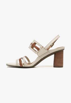 Beige sandal with brown accents, featuring an ankle strap and a chunky, ribbed heel. Strappy design with a square buckle detail.