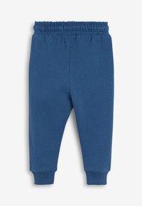 Blå tumling sweatpants med elastisk linning og ribbede manchetter, vist fladt på en hvid baggrund.
