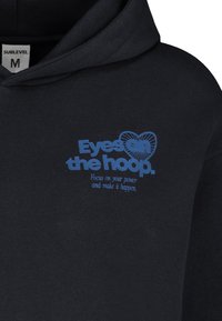 Schwarzer Kapuzenpullover mit blauer Grafikschrift: „Augen auf den Korb. Konzentriere dich auf deine Kraft und setze es um.“ Weicher Stoff, normale Passform, ohne Muster.