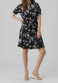 Vestito nero a fiori con maniche corte, vita aderente e dettagli con bottoni; presenta un mix di fiori rosa e blu su un tessuto leggero.