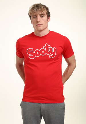 Red cotton t-shirt featuring a large white "Sooty" logo across the chest, round neckline, and short sleeves. Casual fit.