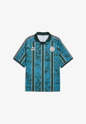 Koszulka piłkarska Manchester City z ciemnozielonymi pionowymi paskami, niebieskim abstrakcyjnym wzorem, logo Puma, sponsorem King oraz czarnym kołnierzem.