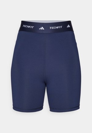 Tamsiai mėlynos sportinės šortai su lygiu paviršiumi, elastinga juosta su "TECHFIT" ir trimis juostelėmis, prigludęs dizainas, minimalus siūlių skaičius.