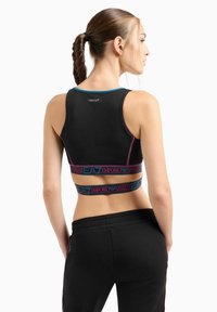 Top corto nero sportivo con accenti blu e rosa, caratterizzato da un design aderente, un elastico con logo "Emporio Armani" e una texture a coste.