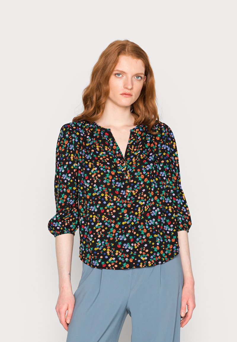 Blusa preta com estampado floral colorido, decote em V e mangas bufantes de três quartos. Tecido leve com um corte descontraído.