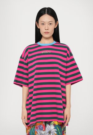 T-shirt overdimensionato con righe orizzontali rosa e verdi, colletto tondo azzurro chiaro e "STIEGLITZ" ricamato sul petto. Materiale in cotone morbido.