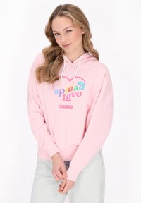 Rózsaszín kapucnis pulóver, melyen a "spread Love" felirat multicolor betűkkel, valamint bordázott mandzsetták találhatók az ujjaknál és a hemnél.