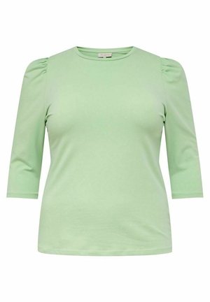 Top verde de manga corta con una textura suave y un diseño ajustado. Presenta detalles fruncidos en los hombros y un escote redondo.