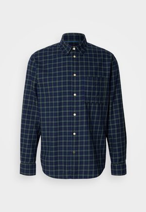 Chemise à carreaux bleu marine et vert foncé en coton, avec un col boutonné, des manches longues et une poche poitrine, dotée de boutons ronds.