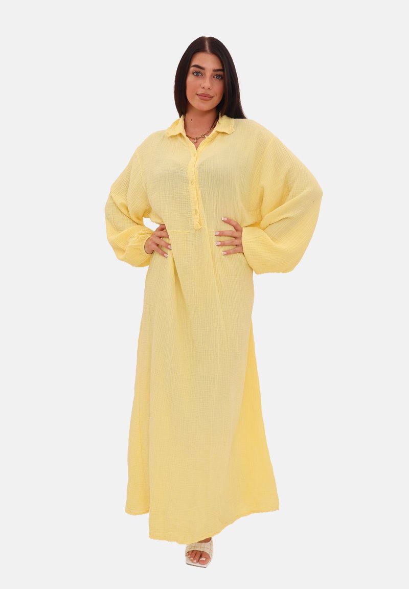 Abito lungo giallo, con bottoni, realizzato in un tessuto textured, con maniche lunghe e voluminose e una vestibilità comoda.