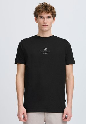 Tricou din bumbac negru cu un logo alb, care include o coroană și textul "KRONSTADT" centrat pe piept. Design cu mâneci scurte și gât rotund.
