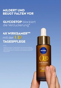 Brown glass dropper bottle with a white lid, featuring blue and gold text. Held in a hand against a blue background.