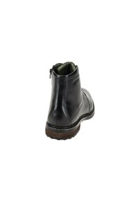 Schwarze Lederstiefelette mit runder Zehenpartie, Seitenreißverschluss und strukturiertem Gummisohle. Mit grünem Innenfutter und feinen Nähten.