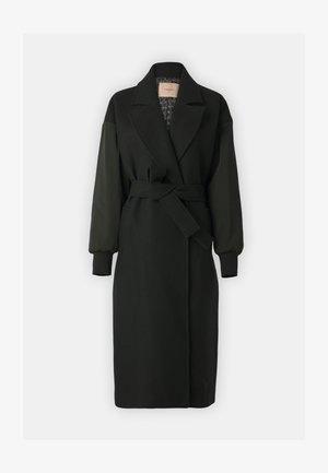 Fekete kabát, szabott gallérral, övvel hangsúlyozott derékkal és hosszú, puffos ujjakkal. Anyagának keverékéből készült, texturált bélés jellemzi.