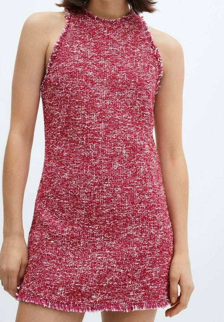 Femme portant une robe sans manches en maille texturée rouge et blanche avec un col montant et un ourlet légèrement effiloché.