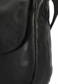 Borsa a spalla in pelle nera con una texture liscia e chiusura a patta curva, caratterizzata da dettagli di cucitura sottili e una tasca laterale.