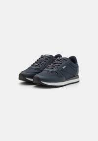 Sneakers blu navale con tomaia in tessuto testurizzato, lacci neri e bianchi a contrasto, suola imbottita e un logo discreto sul lato.