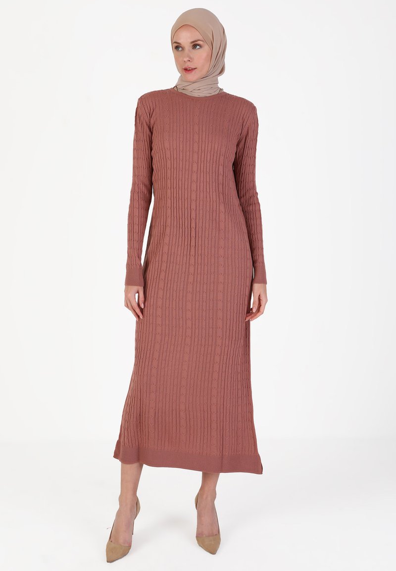 Vestito lungo a coste in rosa tenue, con scollatura rotonda e maniche lunghe. Il tessuto presenta un motivo testurizzato; lunghezza al ginocchio con una silhouette aderente.