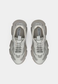 Baskets gris clair avec une tige en maille et cuir, un col rembourré et une semelle en caoutchouc épaisse. Comprend des lacets et un accent réfléchissant.