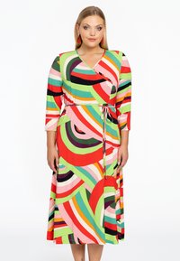 Farbenfrohes Wickelkleid mit kräftigen, wirbelnden Mustern in Rot, Grün, Pink und Schwarz; lange Ärmel und eine Bindegürtel-Detail.