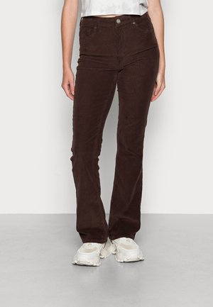 Calças de corduroy castanhas, com corte flare e cintura alta, apresentando bolsos frontais e fecho com botão. O material tem um acabamento suave e texturizado.