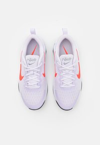 Tenisky Nike s horní částí z jemné fialové síťoviny, jasně oranžovými akcenty, polstrovaným límcem a černou gumovou podrážkou.