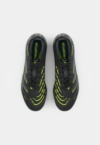 Black athletic shoes with lime green accents, textured upper featuring patterns and stripes, and laced design. Predatory branding visible on sides.