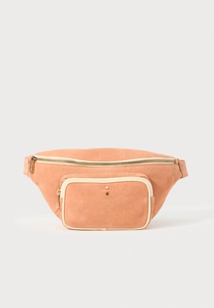 Riñonera de ante durazno con cremallera crema y bolsillo frontal. Presenta un acento dorado y una textura suave, forma redondeada y correa ajustable.