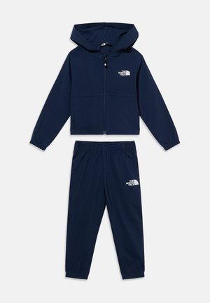 Παιδικό αθλητικό σετ σε ναυτικό μπλε, με φούτερ με κουκούλα και φερμουάρ, και παντελόνι με ελαστική μέση, με το λογότυπο The North Face στο στήθος και στον μηρό.