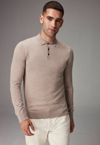 Beige hosszú ujjú pólóing, gallérral és háromgombos nyakkal; puha anyagból készült, testhezálló szabású és bordázott mandzsettával.