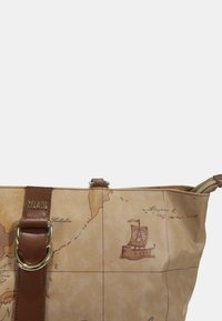 Borsa tote T'Classe in beige con stampa della mappa del mondo, caratterizzata da accenti in pelle marrone, una doppia fibbia in metallo e una chiusura superiore con zip.