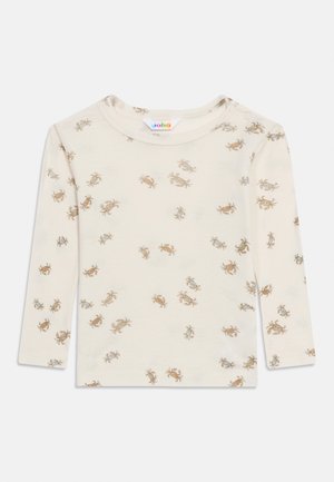 Kreemikas pikakäteline imikute särk väikeste pruunide ja siniste krabidega ning õlale kinnitatavate trukkidega mugavaks riietumiseks.