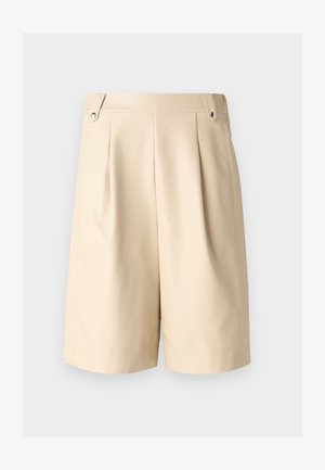 Beige plisētie šorti ar gludu tekstūru, kuriem ir divas sānu kabatas un sudraba aksesuāri jostas vietā.